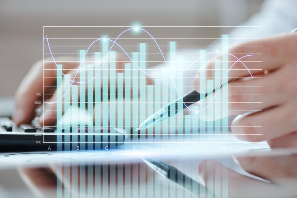 Business person analyzing dropshipping growth data with digital bar and line charts overlayed on a screen.